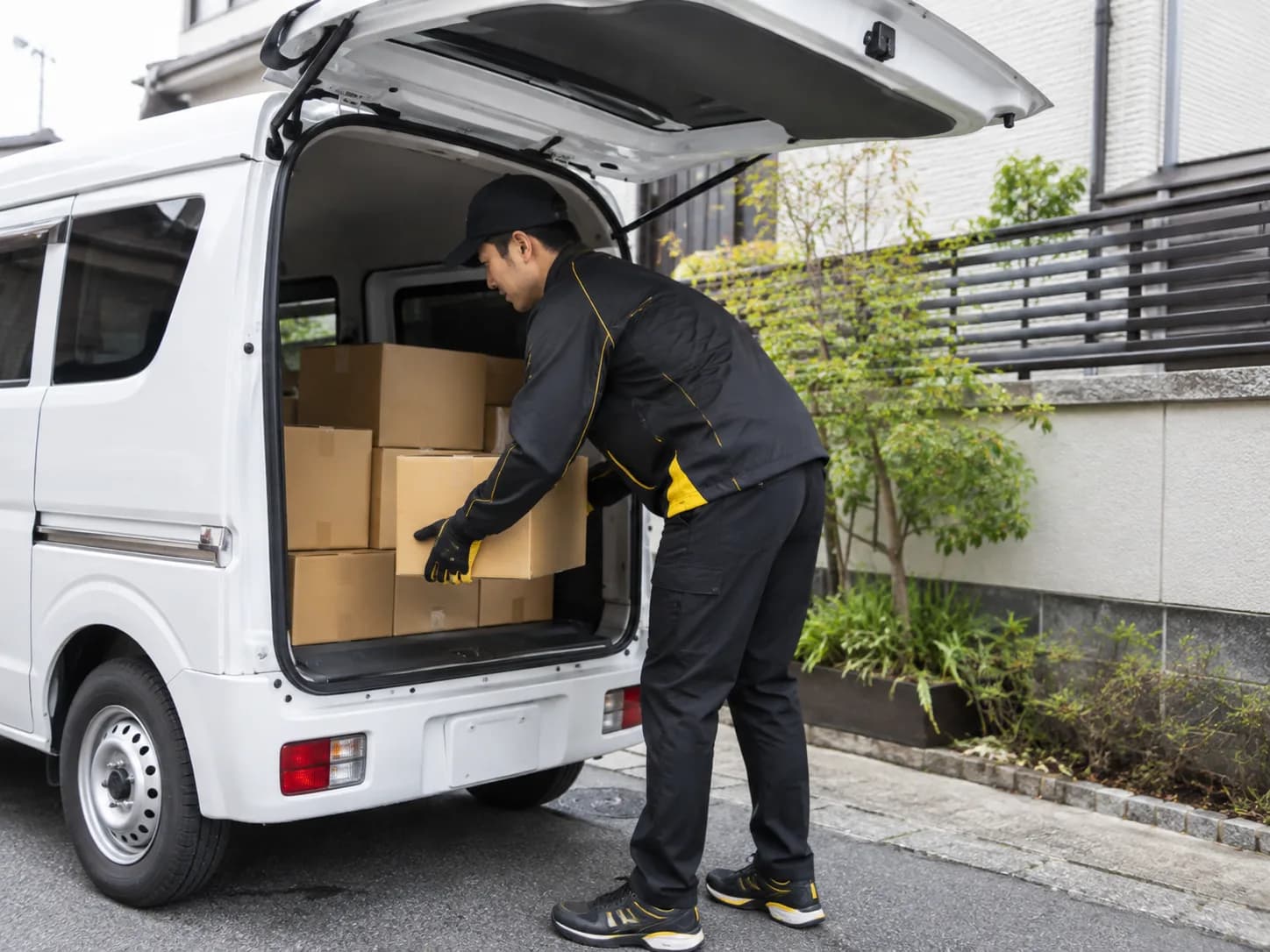 配送前に軽バンへ荷物を積み込む様子